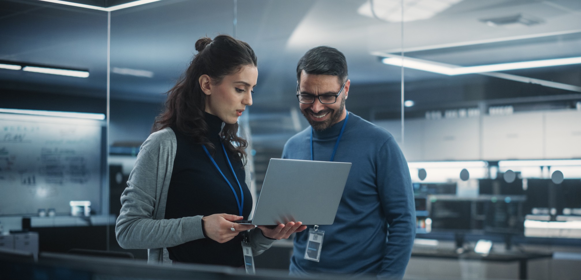 Frau und Mann schauen auf Laptop und besprechen sich